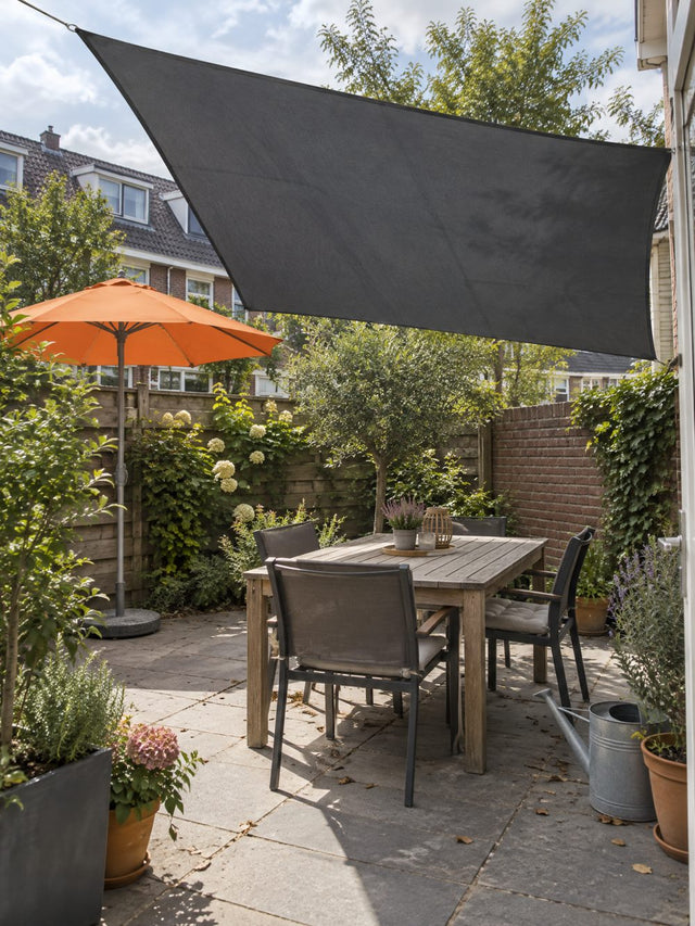 Tuin met schaduwdoek en parasol