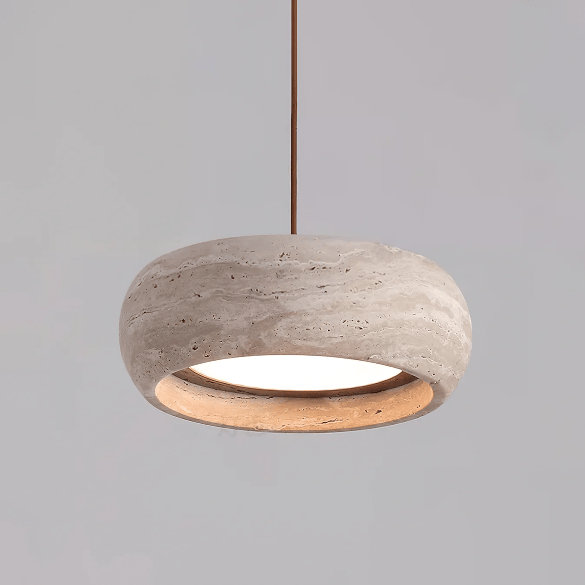 Ronde travertijn hanglamp in donutvorm aan een zwarte metalen stang