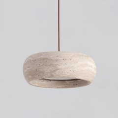 Ronde travertijn hanglamp in donutvorm aan een zwarte metalen stang