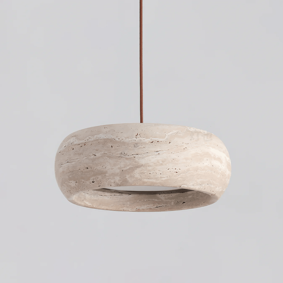 Ronde travertijn hanglamp in donutvorm aan een zwarte metalen stang
