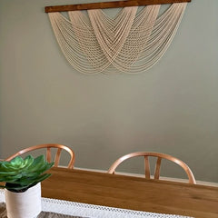 Geknoopt macramé wandpaneel van katoen aan een muur