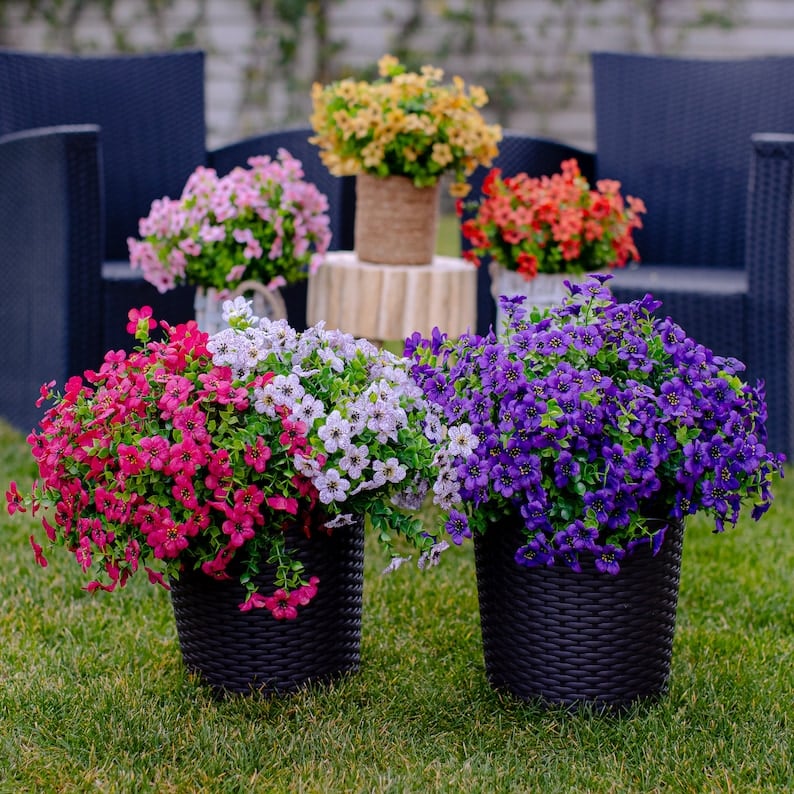 Kleurrijke kunstbloemen in een plantenbak op het balkon