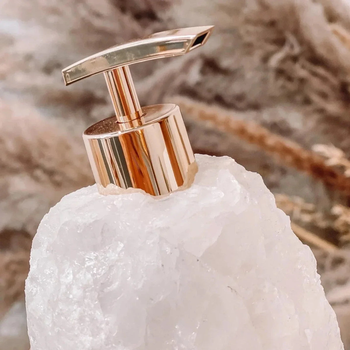 Zeepdispenser van natuursteen met pomp op een wastafel