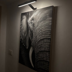 Draadloze LED-schilderijlamp boven een schilderij aan de muur