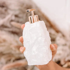 Zeepdispenser van natuursteen met pomp op een wastafel