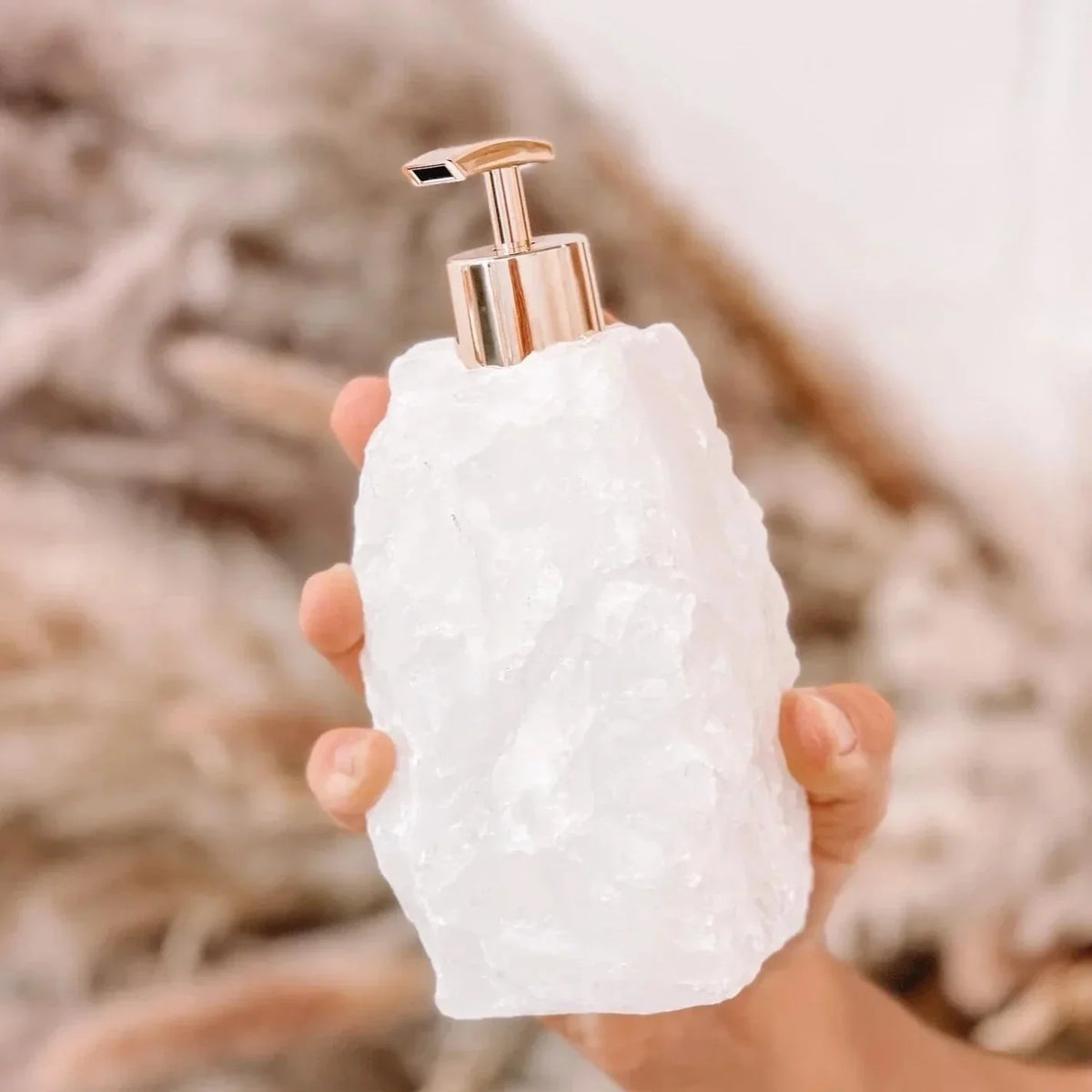 Zeepdispenser van natuursteen met pomp op een wastafel