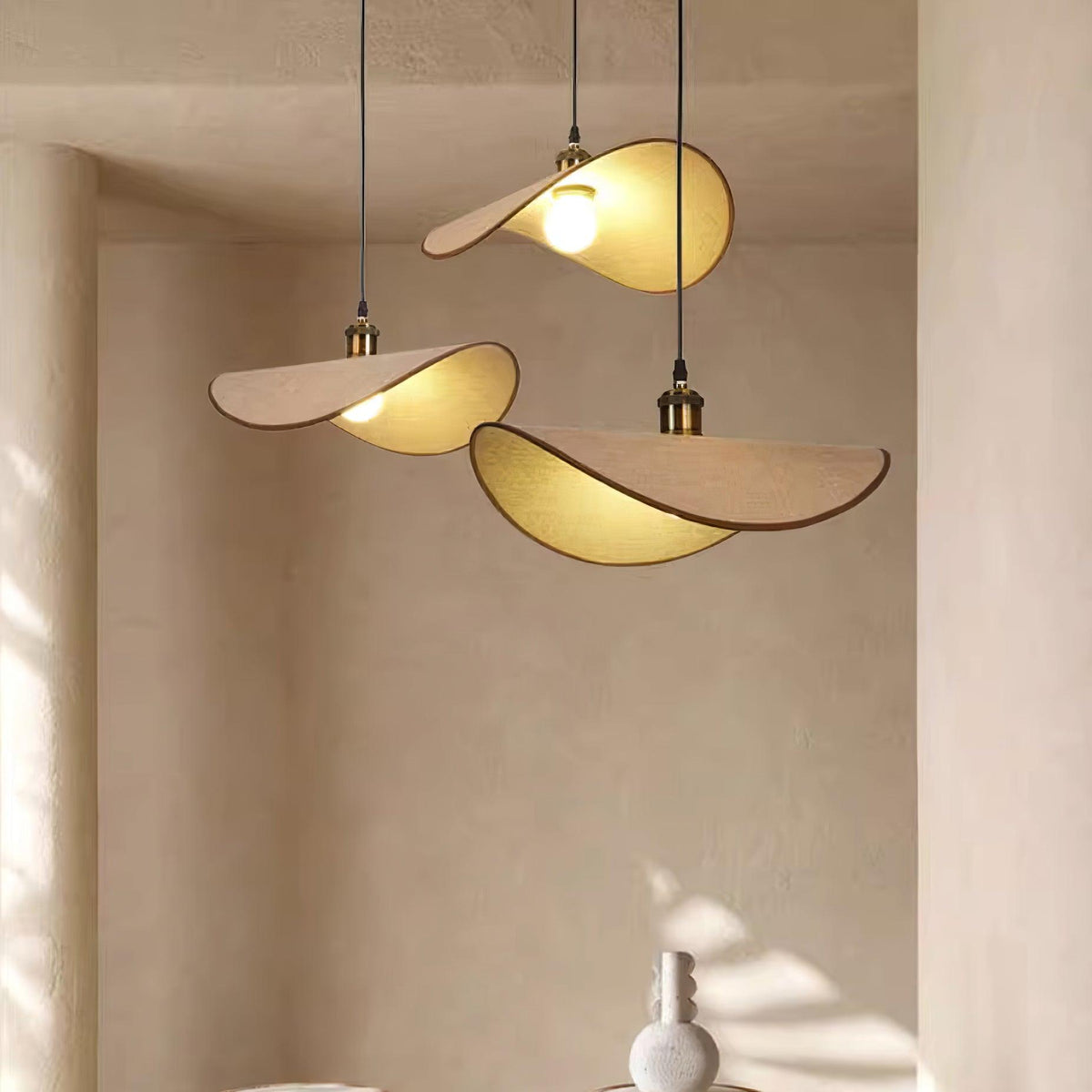 Hanglamp met ronde linnen kap en houten accenten boven een eettafel