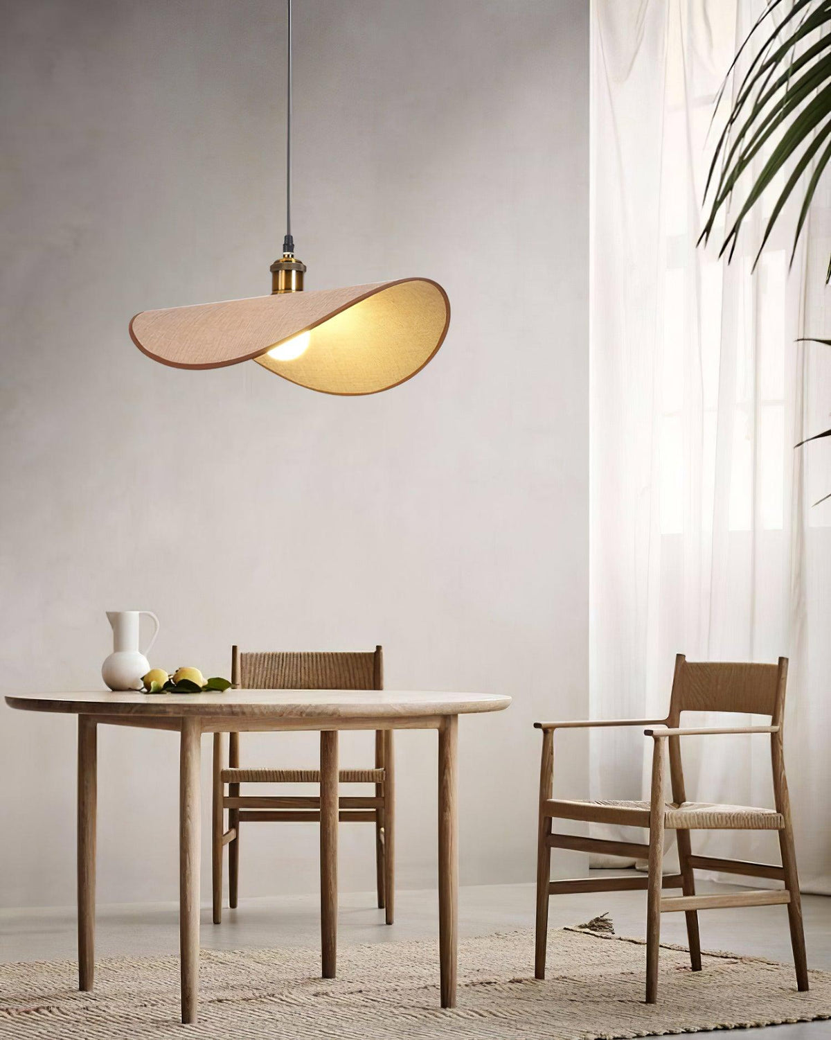 Hanglamp met ronde linnen kap en houten accenten boven een eettafel