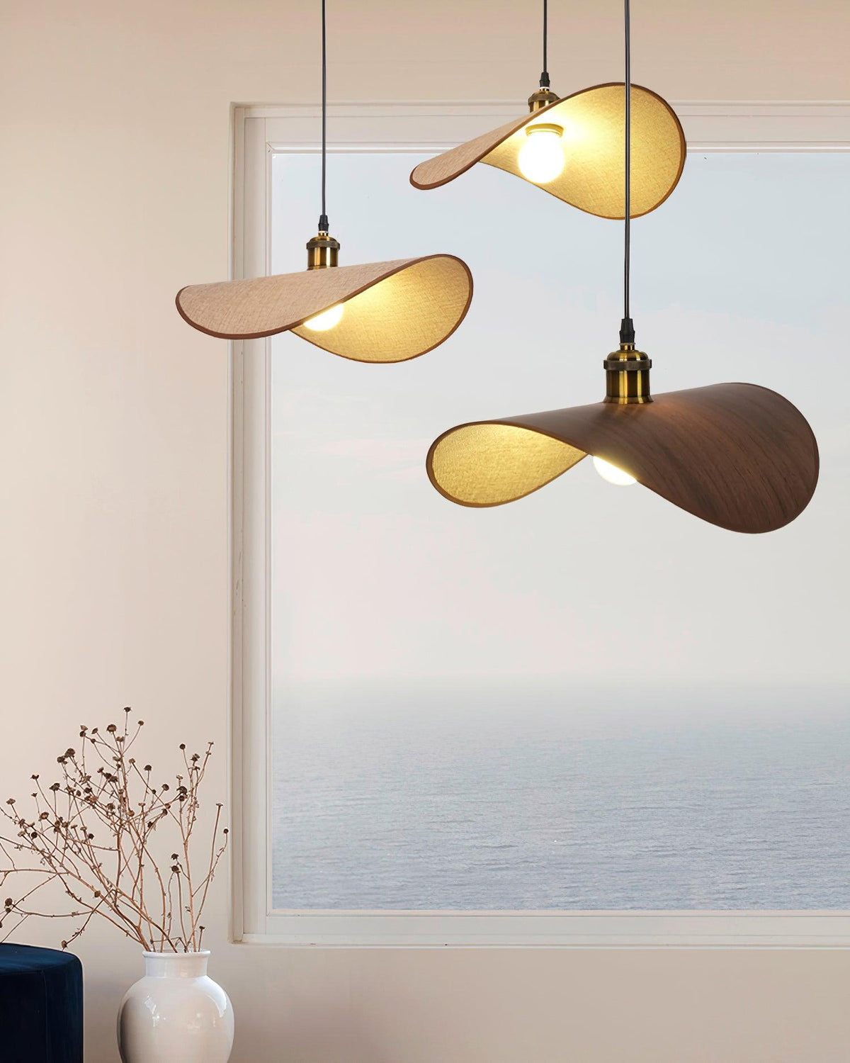 Hanglamp met ronde linnen kap en houten accenten boven een eettafel