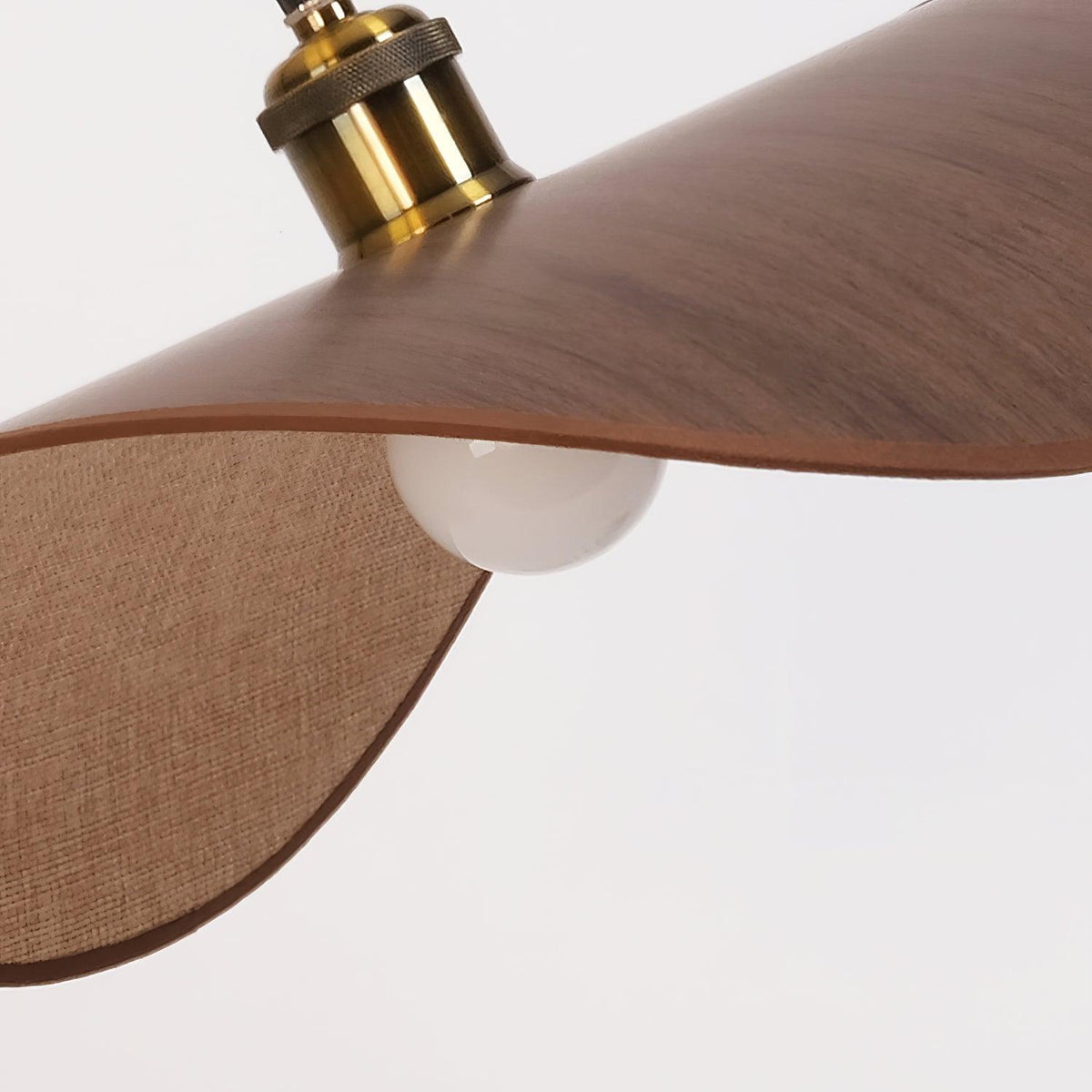 Hanglamp met ronde linnen kap en houten accenten boven een eettafel