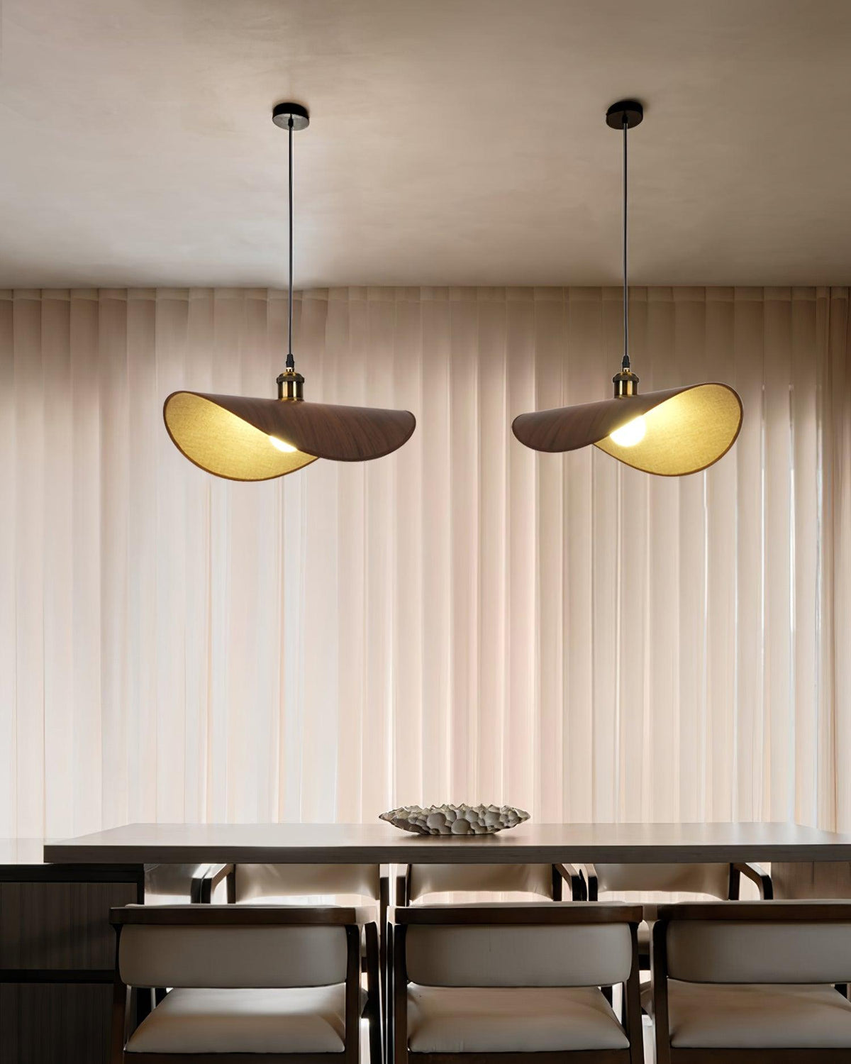Hanglamp met ronde linnen kap en houten accenten boven een eettafel