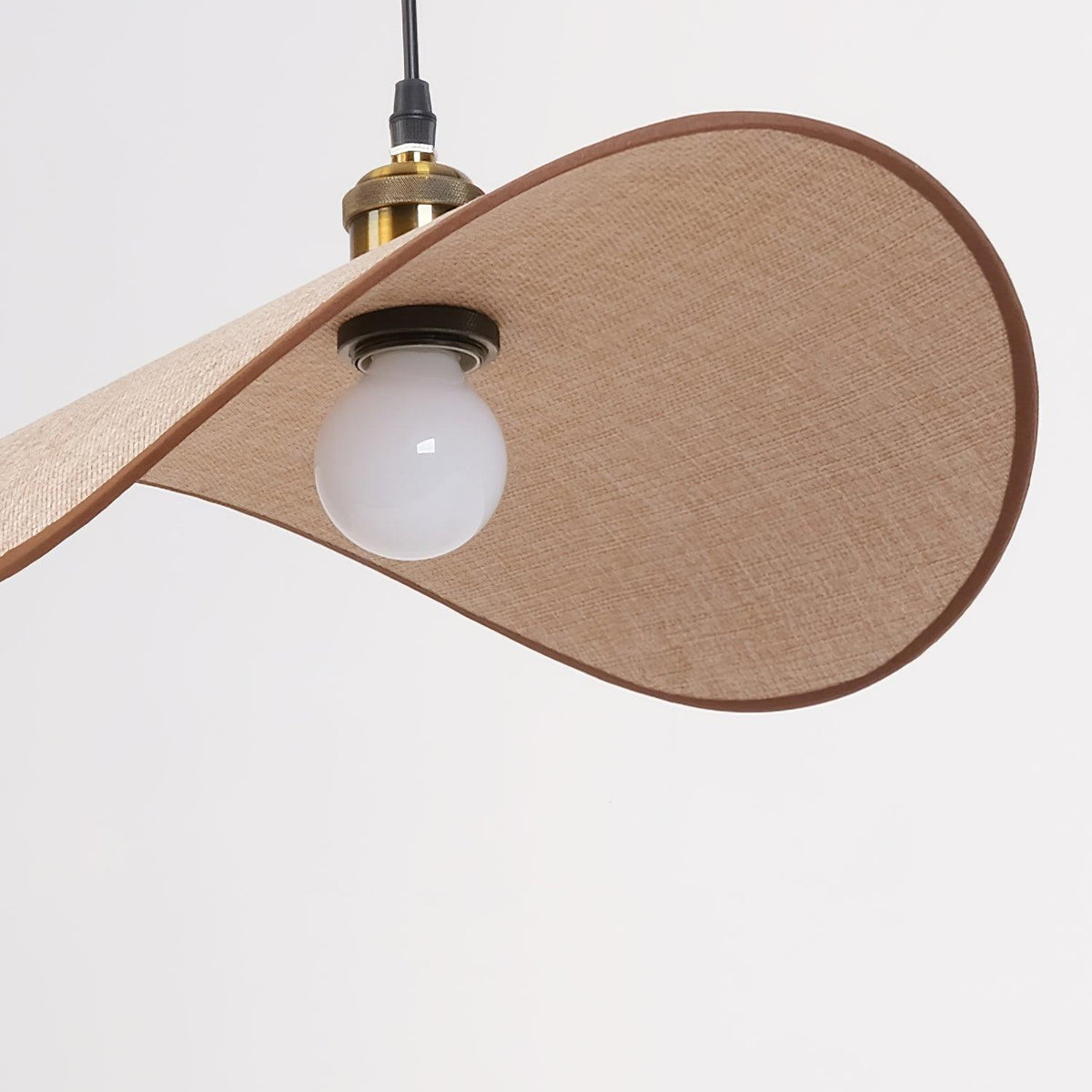 Hanglamp met ronde linnen kap en houten accenten boven een eettafel
