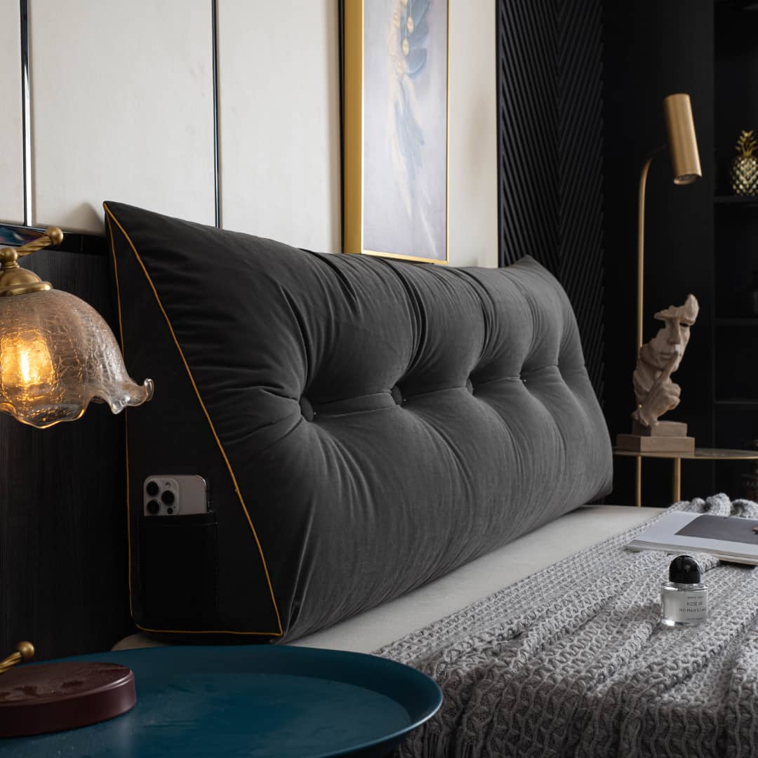 Driehoekig wigkussen tegen het hoofdeinde van een bed
