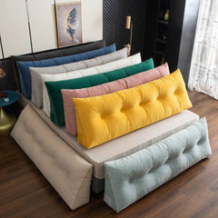 Driehoekig wigkussen tegen het hoofdeinde van een bed