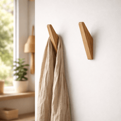Tweekleurige houten wandhaken naast elkaar aan de muur