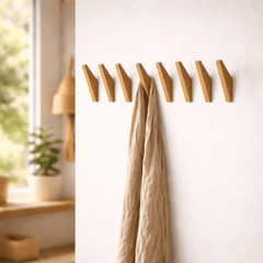 Tweekleurige houten wandhaken naast elkaar aan de muur