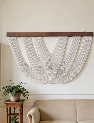 Geknoopt macramé wandpaneel van katoen aan een muur