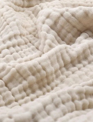 Mousseline plaid gedrapeerd over een bank