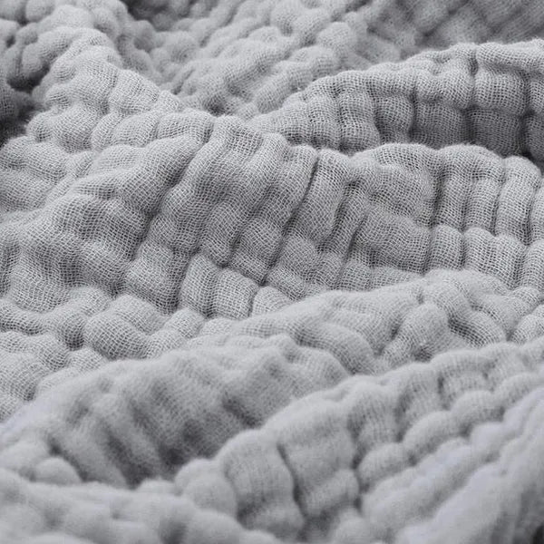 Mousseline plaid gedrapeerd over een bank
