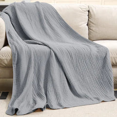 Mousseline plaid gedrapeerd over een bank