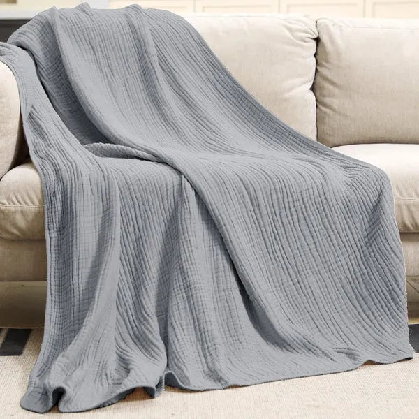 Mousseline plaid gedrapeerd over een bank