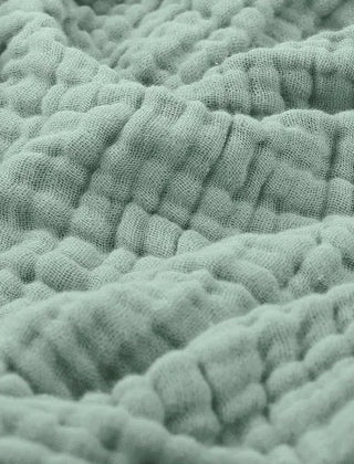 Mousseline plaid gedrapeerd over een bank